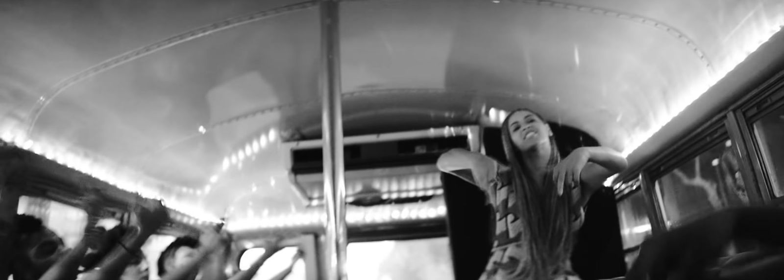 a black and white photo of a woman on a bus