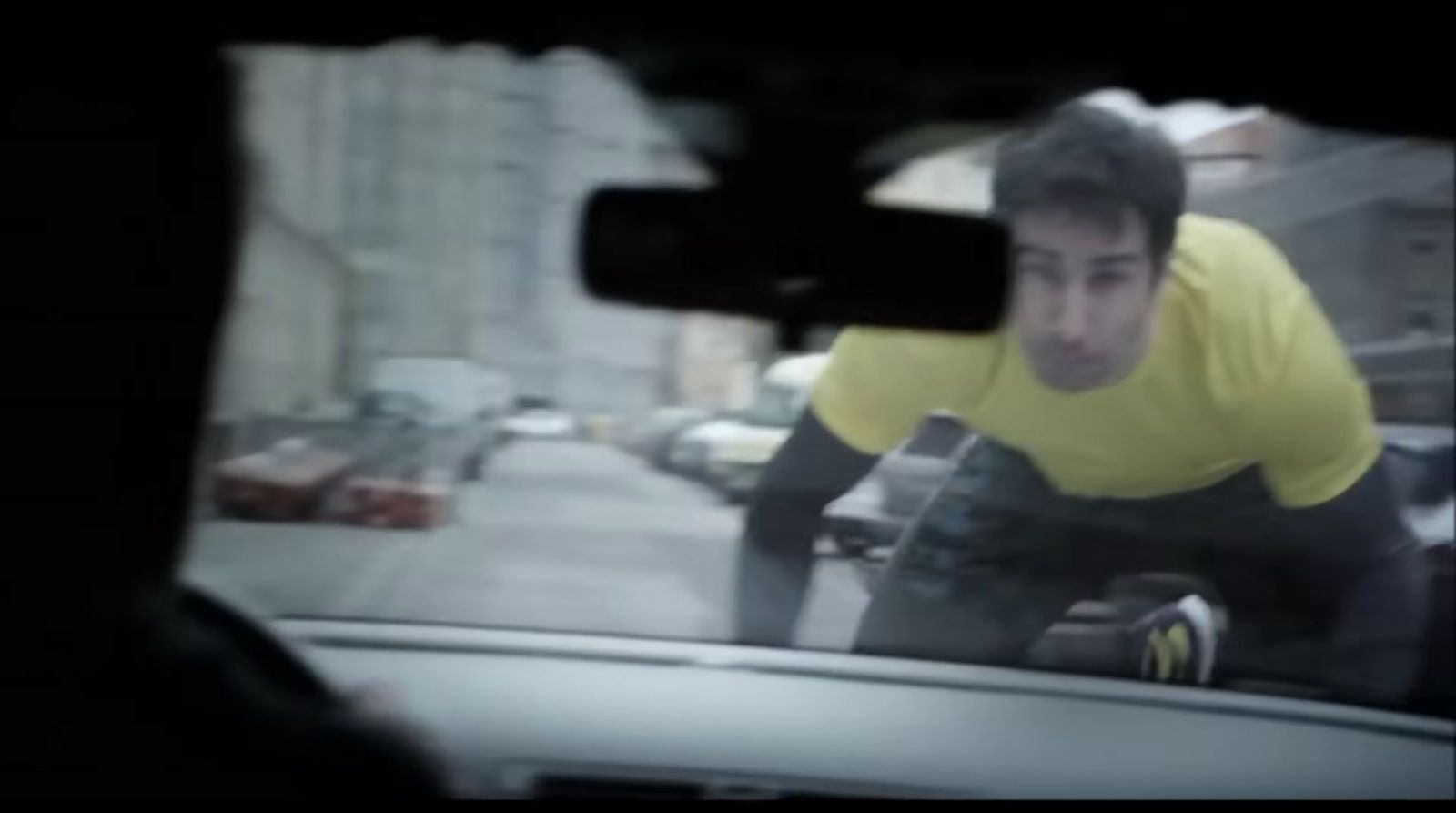 a man riding a bike down a street next to a car