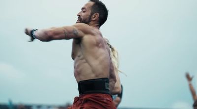 a shirtless man throwing a frisbee in the air