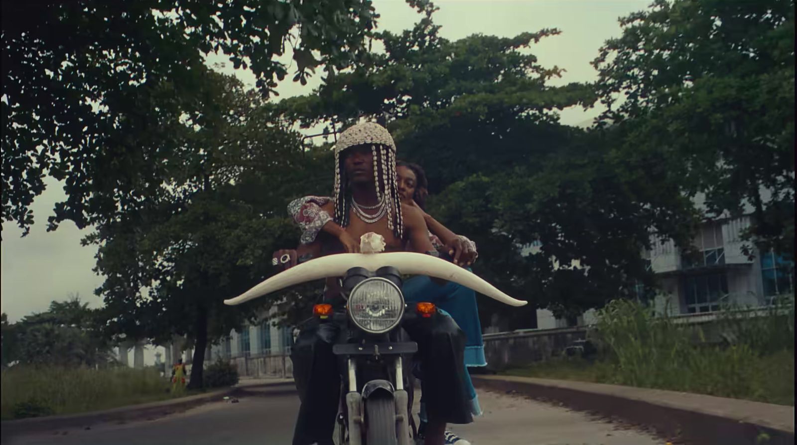 a woman riding on the back of a motorcycle down a street