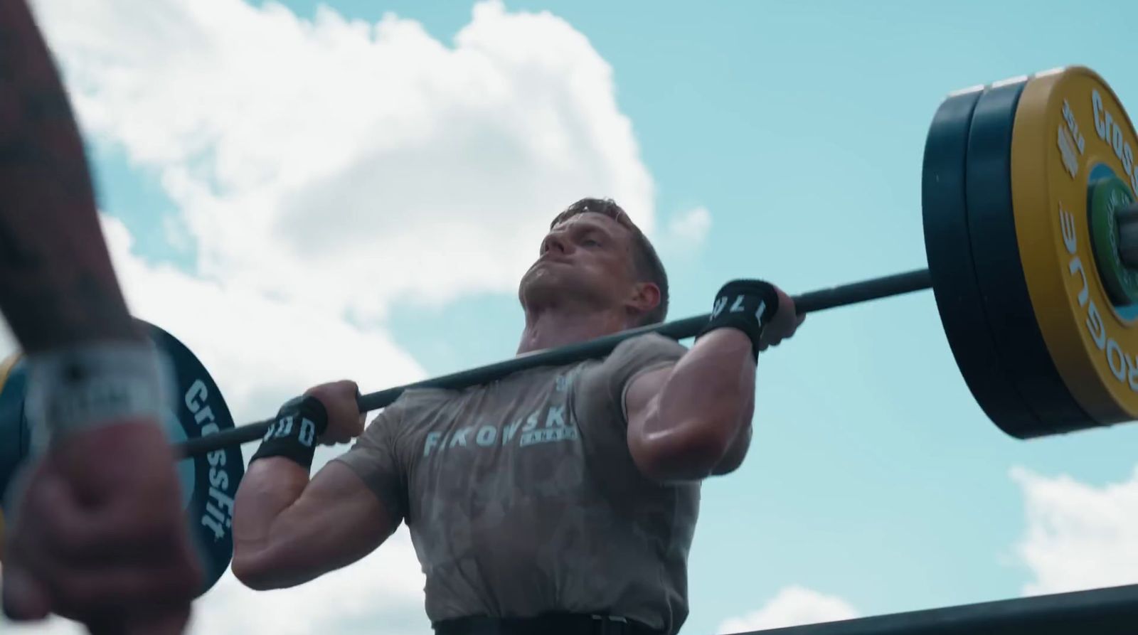 a man holding a barbell in front of his face