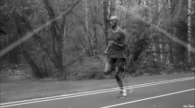 a man running on a road in the woods