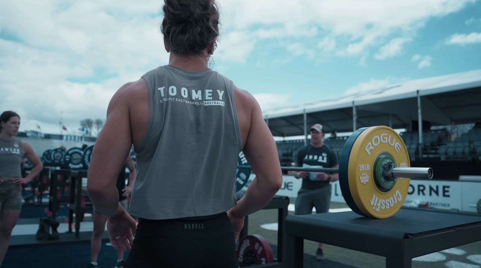 a man standing in front of a barbell in a gym