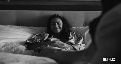 a woman laying in bed with a blanket over her head