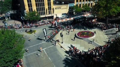 a crowd of people standing on a street corner