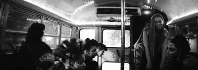 a black and white photo of people on a bus