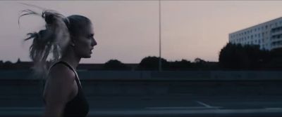 a woman with long hair standing in a parking lot