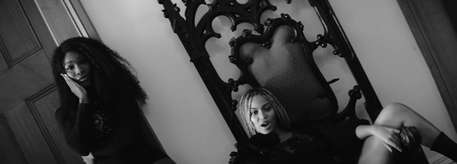 a black and white photo of two women in front of a mirror