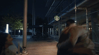 a man and a woman walking down a sidewalk at night