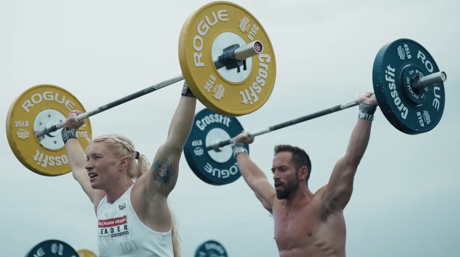 a man and a woman lifting a barbell