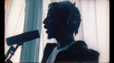 a man with headphones standing in front of a microphone