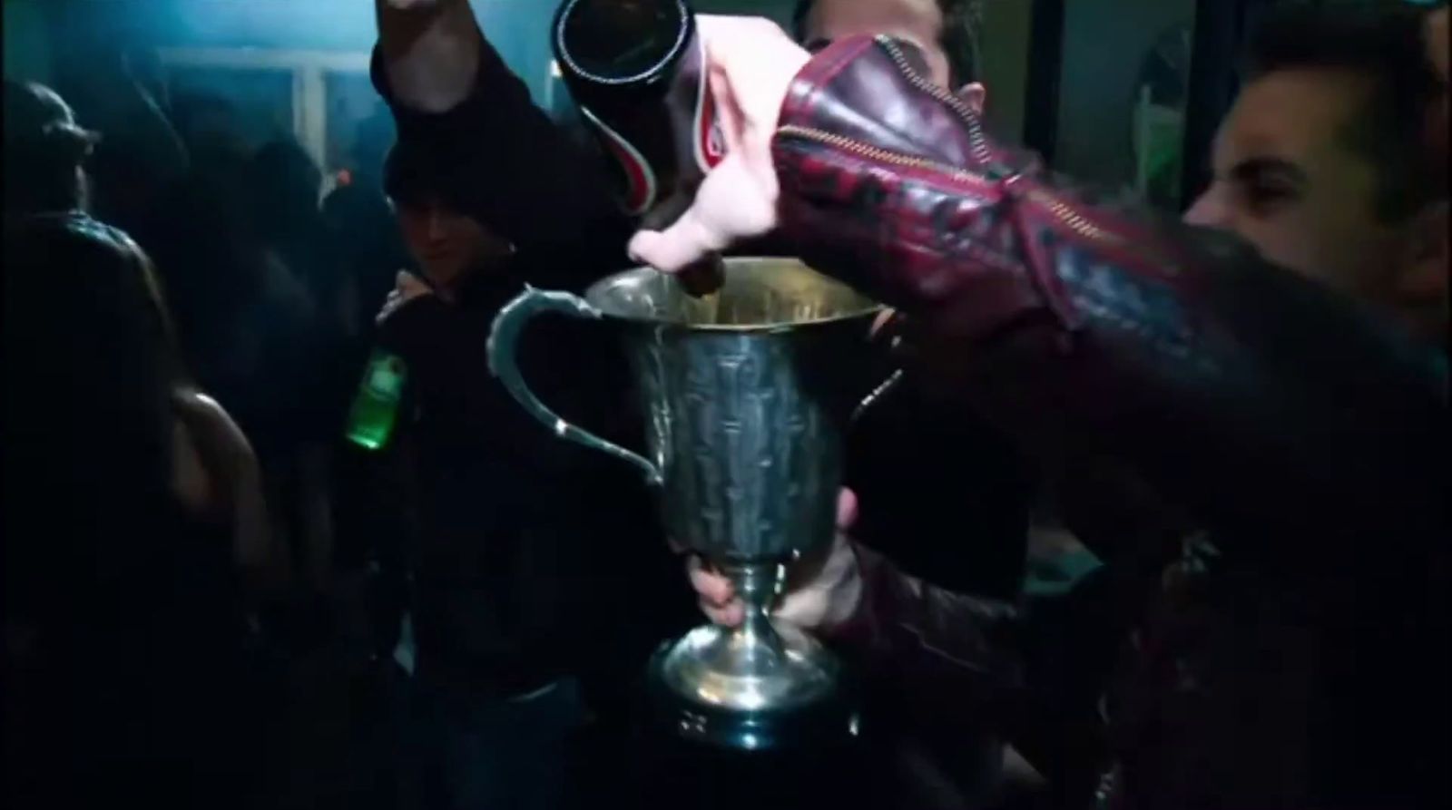 a man in a leather jacket holding a trophy