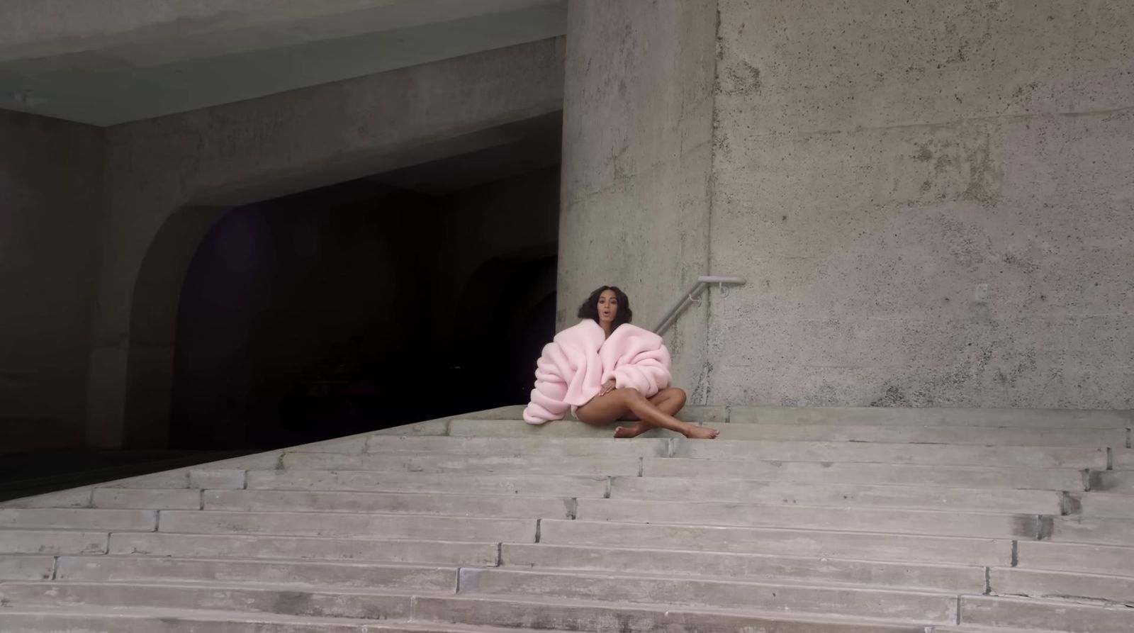 a woman in a bathrobe sitting on some steps