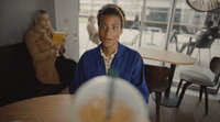 a woman sitting at a table with a glass in front of her