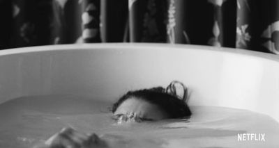 a woman in a bathtub with her head in the water