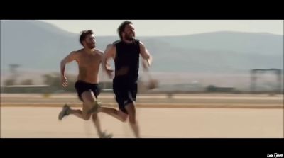 a couple of men running across a field