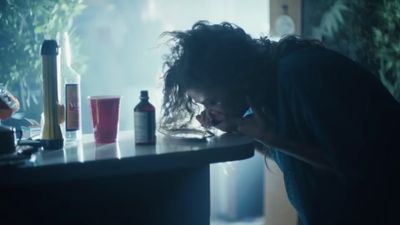 a man leaning on a counter talking on a cell phone