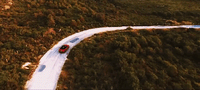 a red car driving down a winding road