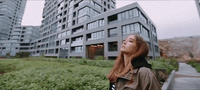 a woman standing in front of a tall building