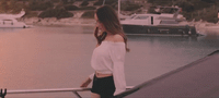 a woman standing on a boat looking at the water