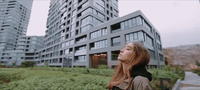 a woman standing in front of a tall building