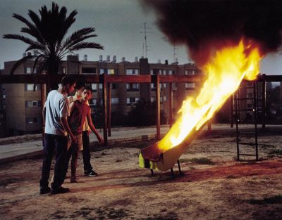 a group of people standing around a fire pit