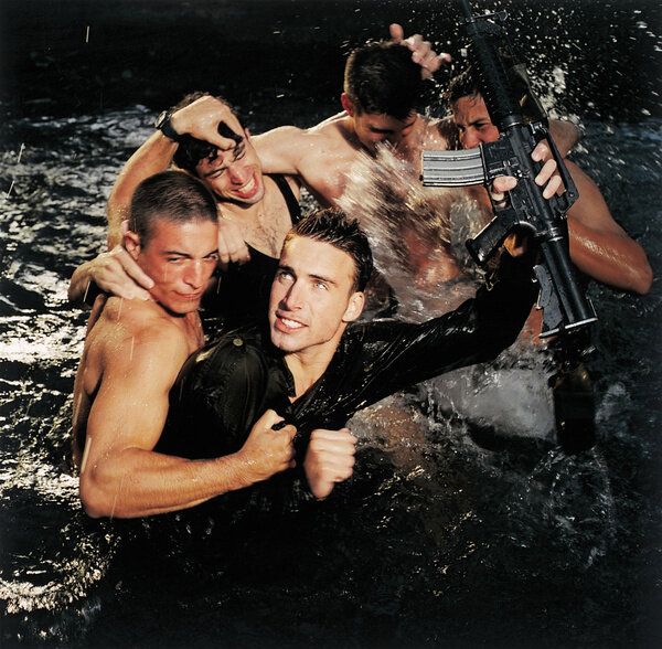 a group of men in the water with guns