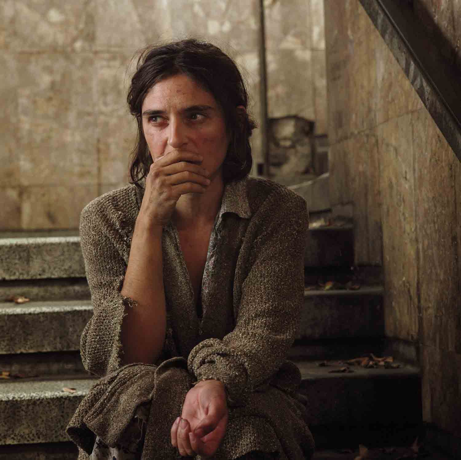 a woman sitting on the steps of a building