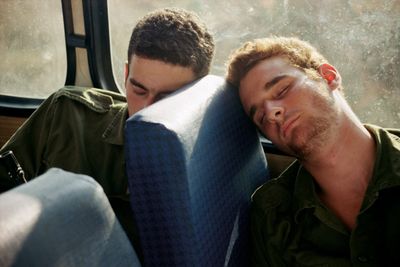 a couple of men sitting next to each other on a bus