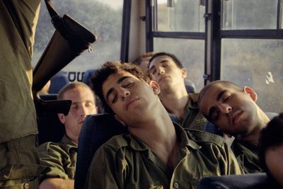 a group of men sitting next to each other on a bus