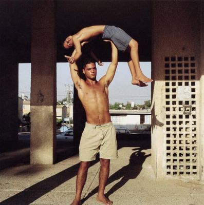 a man is doing a handstand on another man