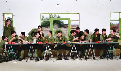 a group of men sitting at a table eating food