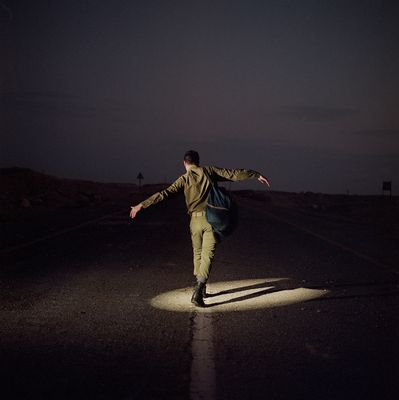 a man walking across a street at night
