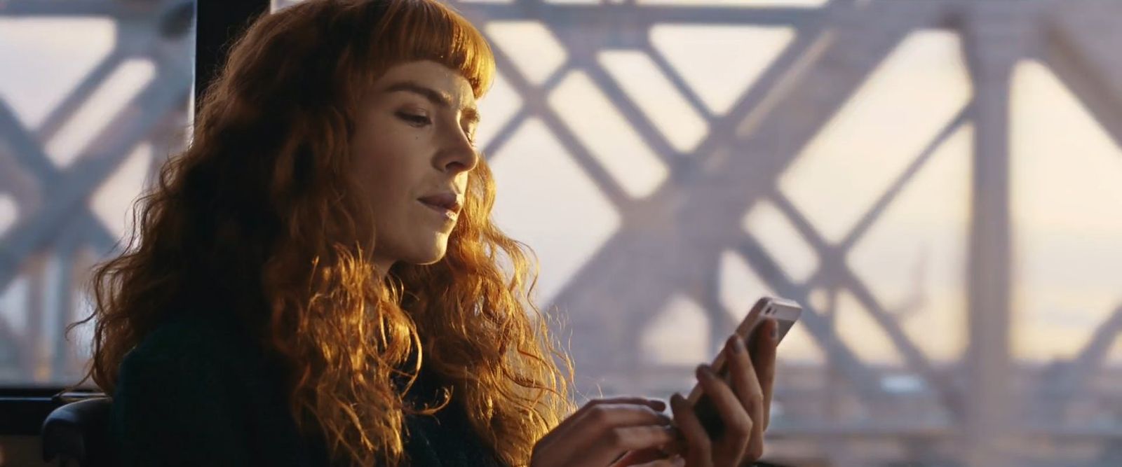 a woman looking at her cell phone while sitting on a train