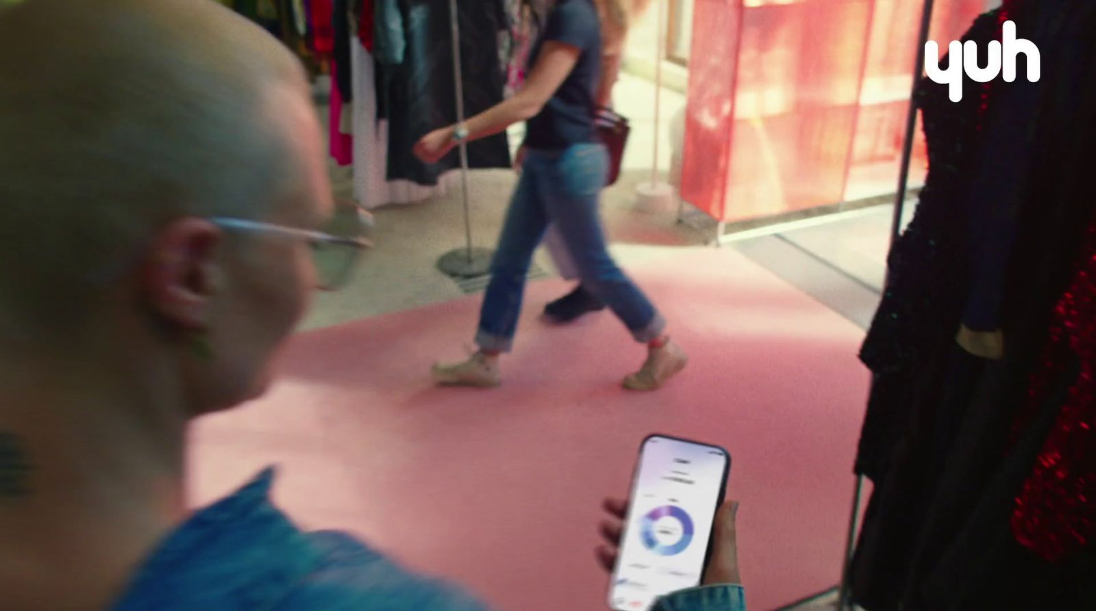 a woman is looking at her cell phone in a clothing store