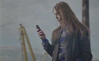 a man with long hair looking at his cell phone