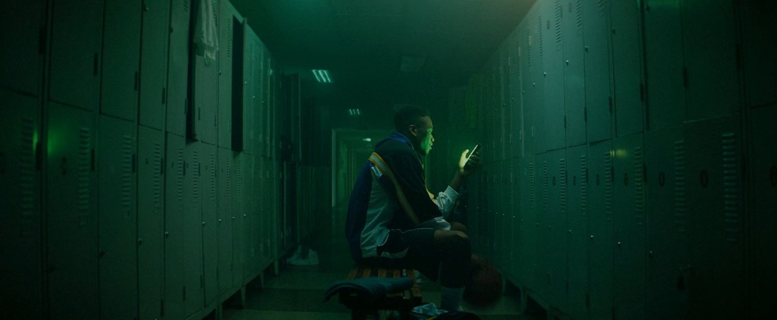 a man standing in a hallway next to lockers