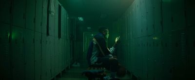 a man standing in a hallway next to lockers