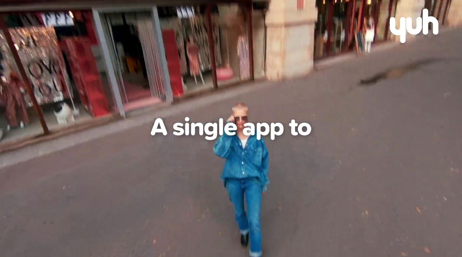 a man walking down a street while talking on a cell phone