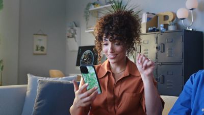 a man and a woman sitting on a couch looking at a cell phone