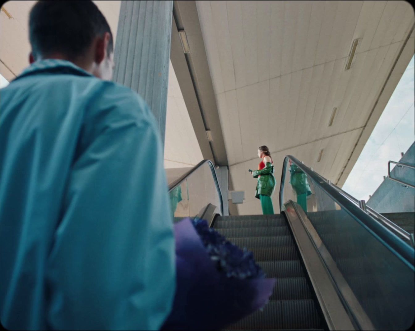 a couple of people riding down an escalator