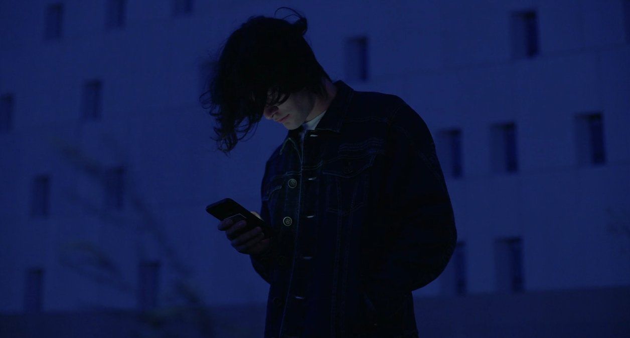 a person standing in the dark using a cell phone