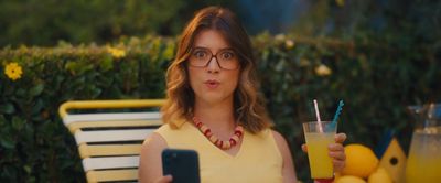 a woman holding a drink and a cell phone