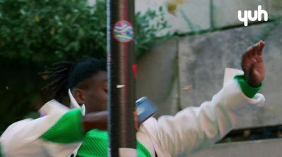 a woman in a green and white jacket holding a cell phone