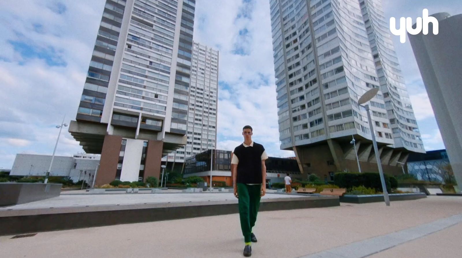 a man standing in front of tall buildings