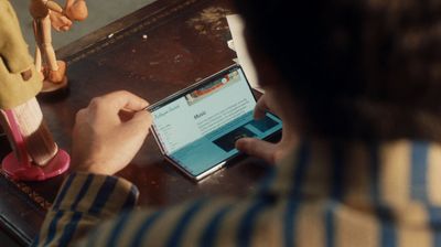 a man sitting at a table using a tablet computer