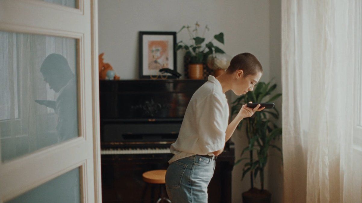 a boy standing in front of a piano looking at his cell phone