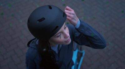 a woman wearing a helmet and holding a baseball bat