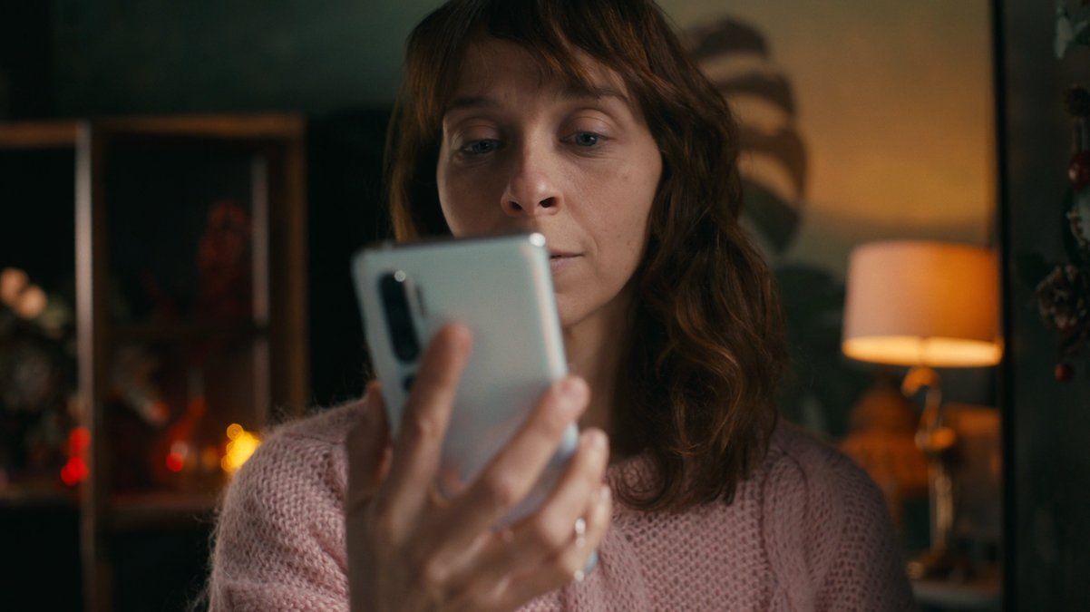 a woman looking at her cell phone in a dark room