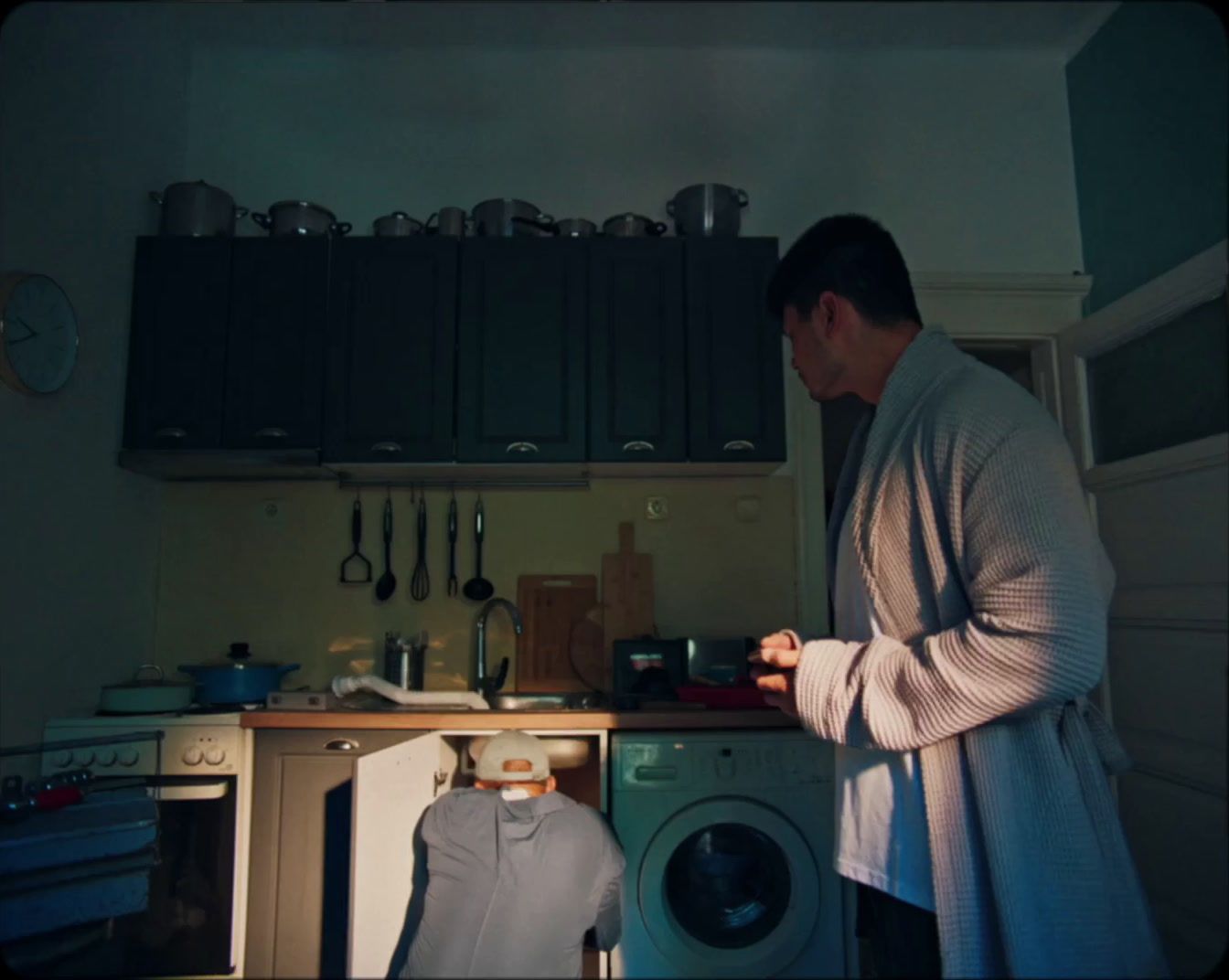 a man standing in a kitchen next to a washing machine